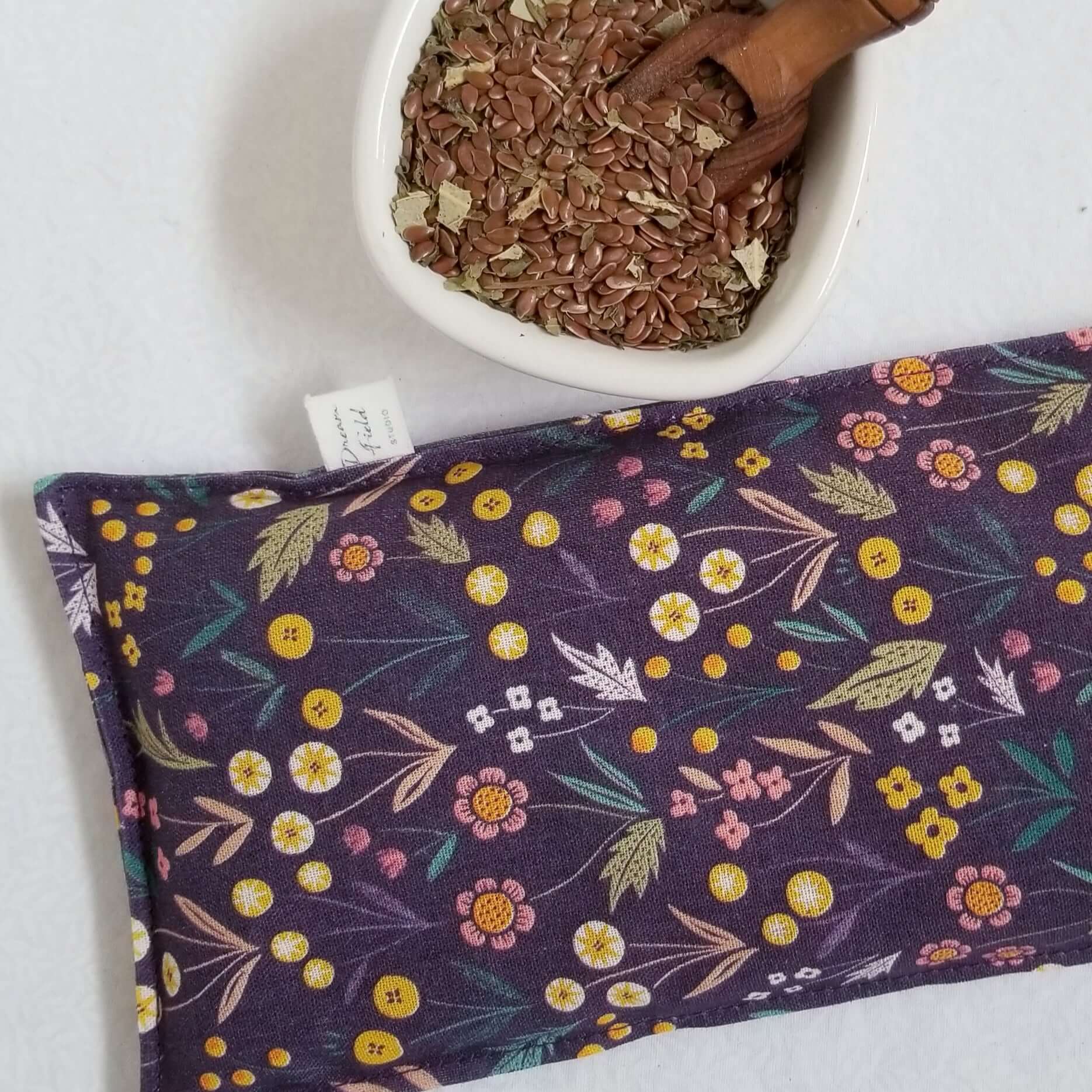 Eucalyptus mint eye pillow forest floral print and bowl of flax seeds and fresh dried herbs