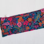 Liberty of London Ciara eye pillow with blues and vivid pink floral design laid flat