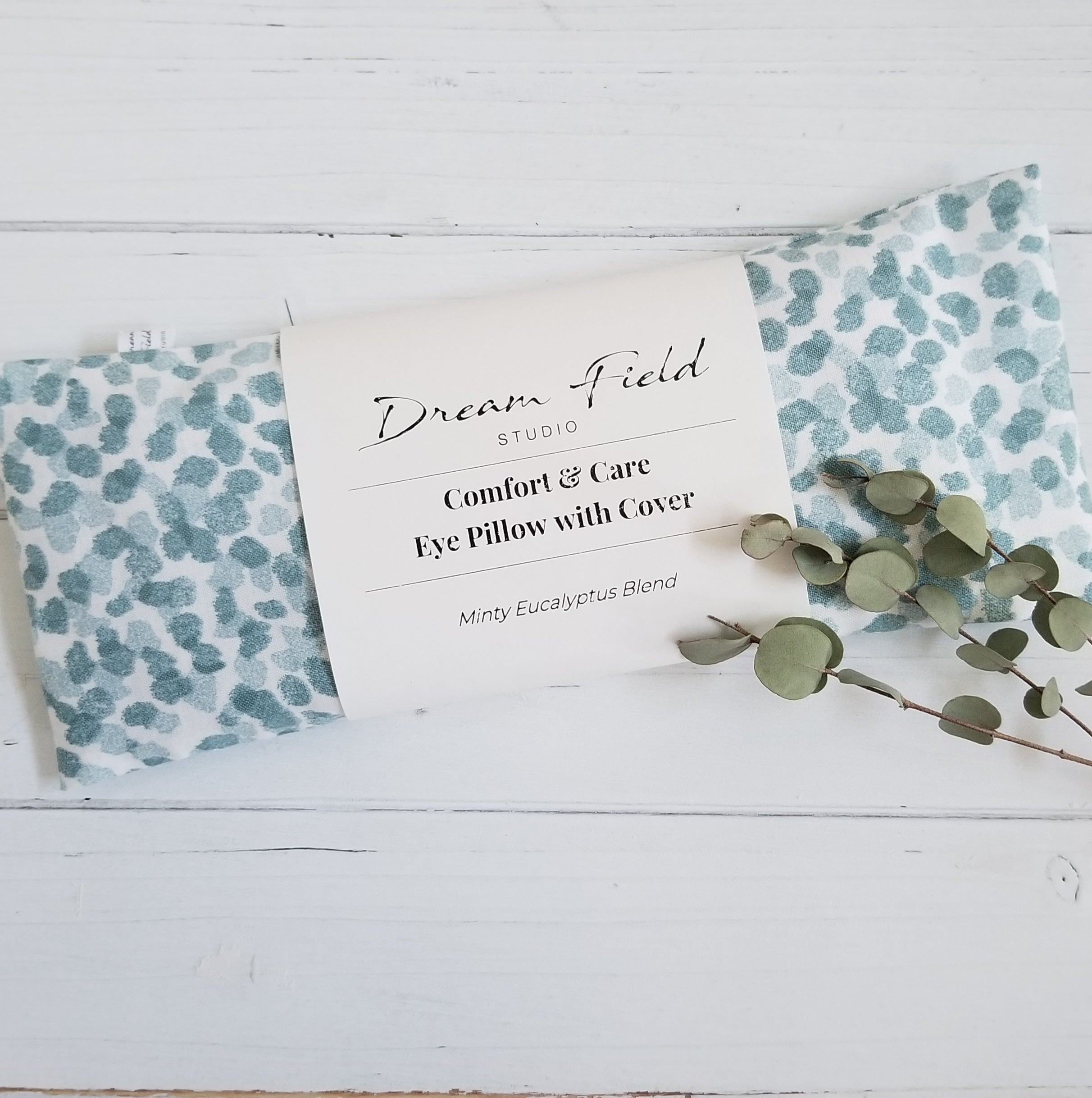 Minty eucalyptus blend eye pillow in blue spa dot print and sprig of eucalyptus leaves by Dream Field Studio