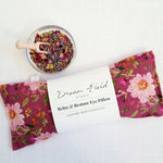 organic lavender eye pillow with deep rose floral print and bowl of dried herbs