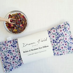 lavender eye pillow with bowl of dried herbs