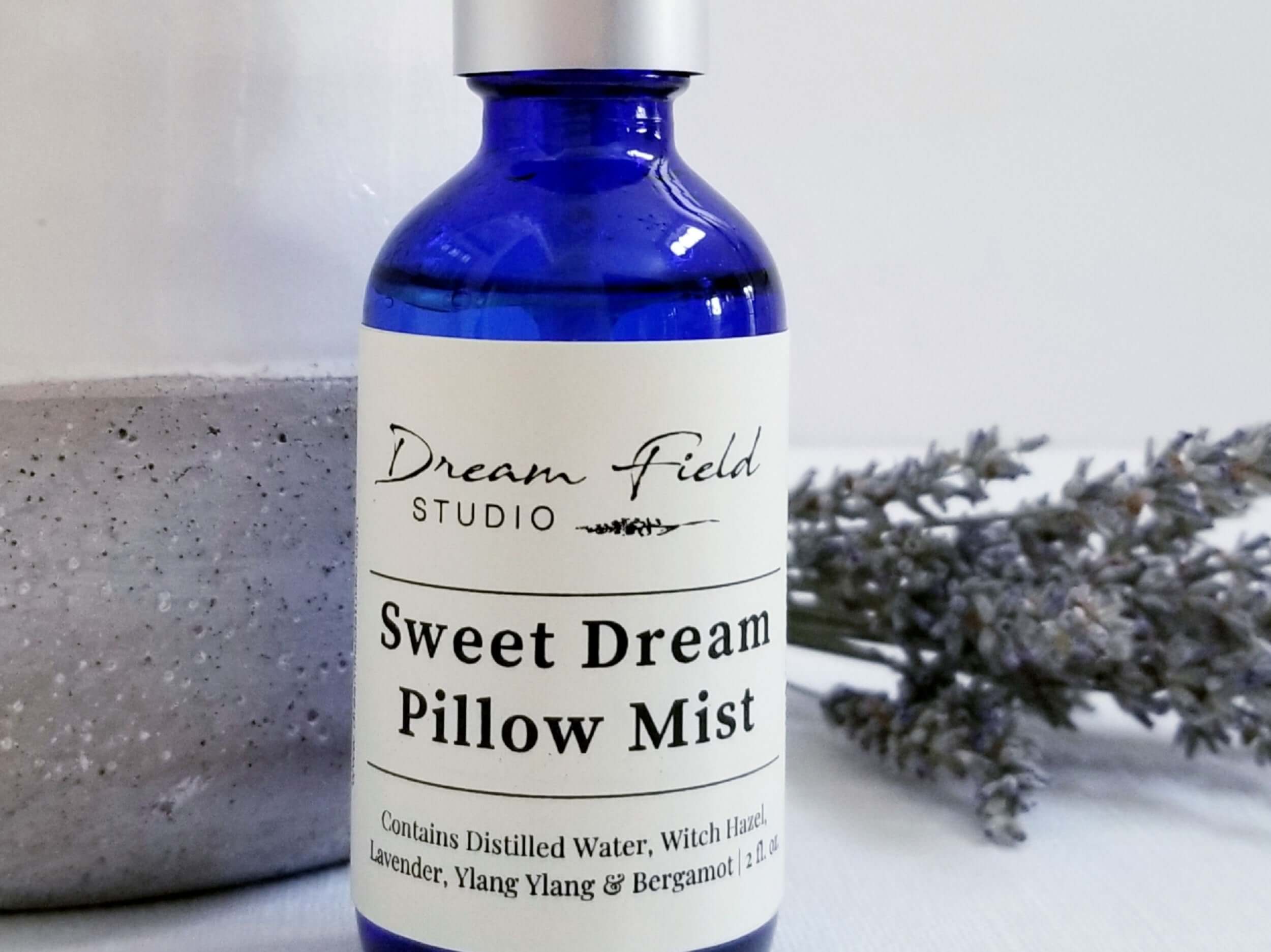 Close up of Sweet Dream Pillow Mist spray in blue glass bottle