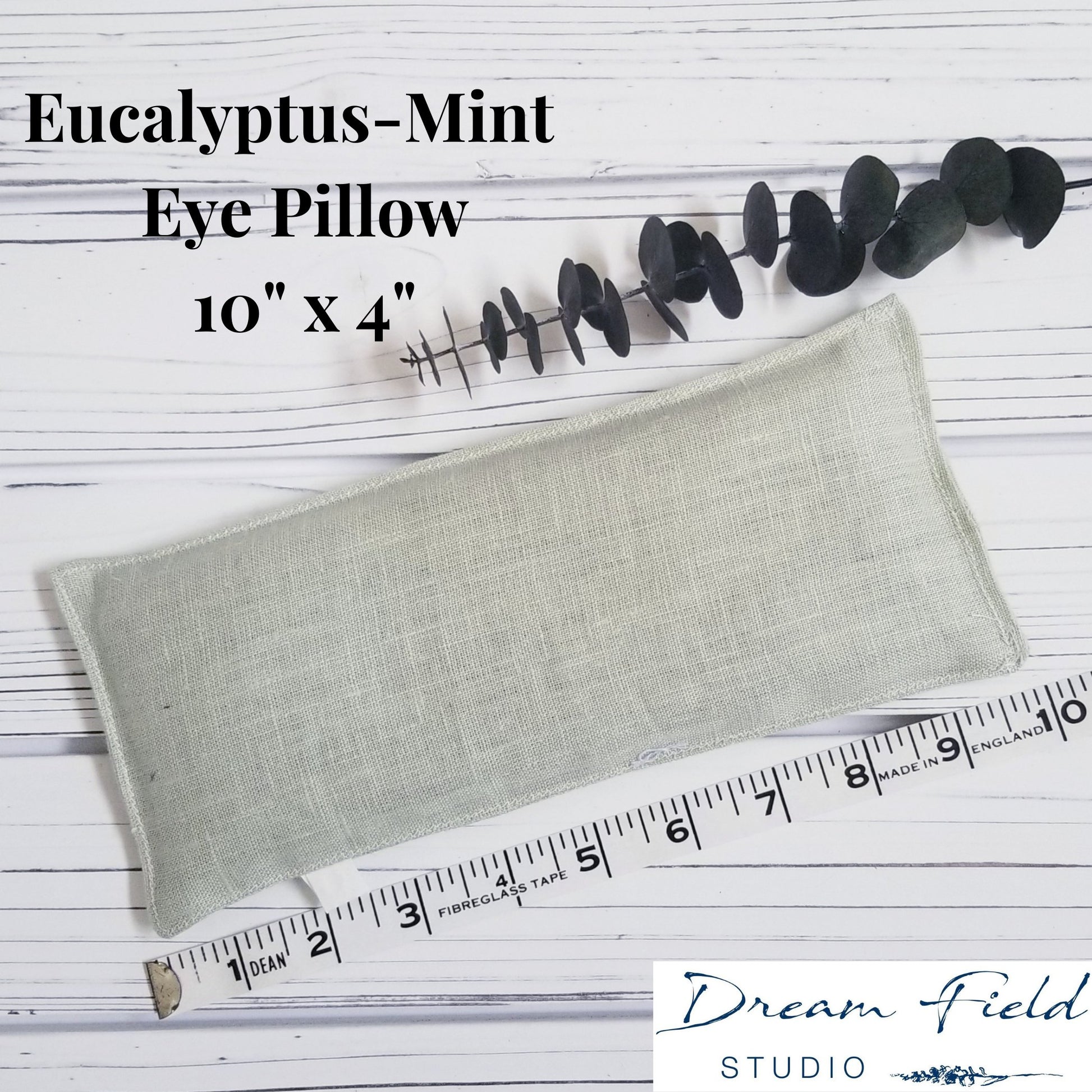 Size specifications of 10" x 4" eucalyptus-mint eye pillow and sprig of eucalyptus leaves by Dream Field Studio