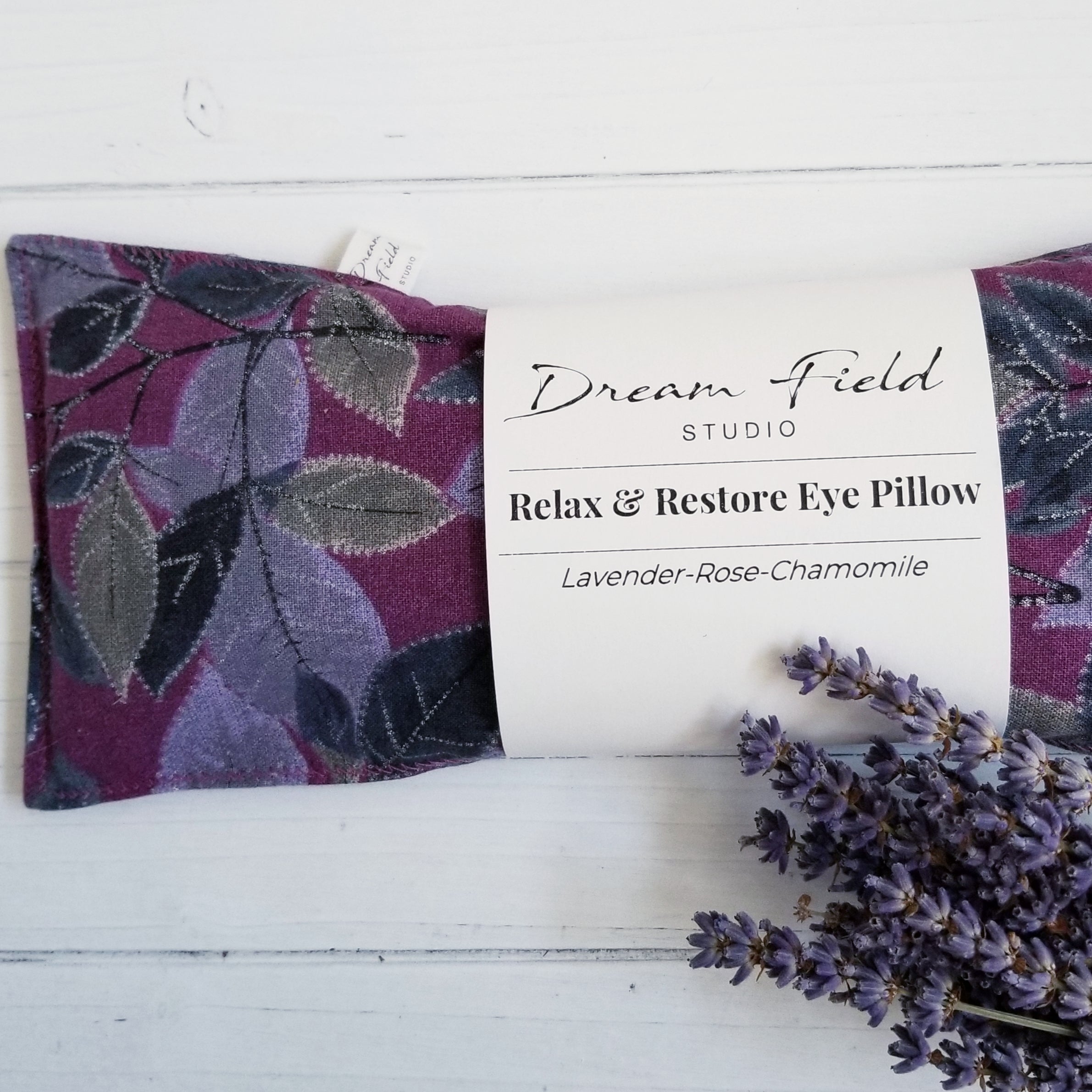 lavender eye pillow with bunch of dried stems of lavender