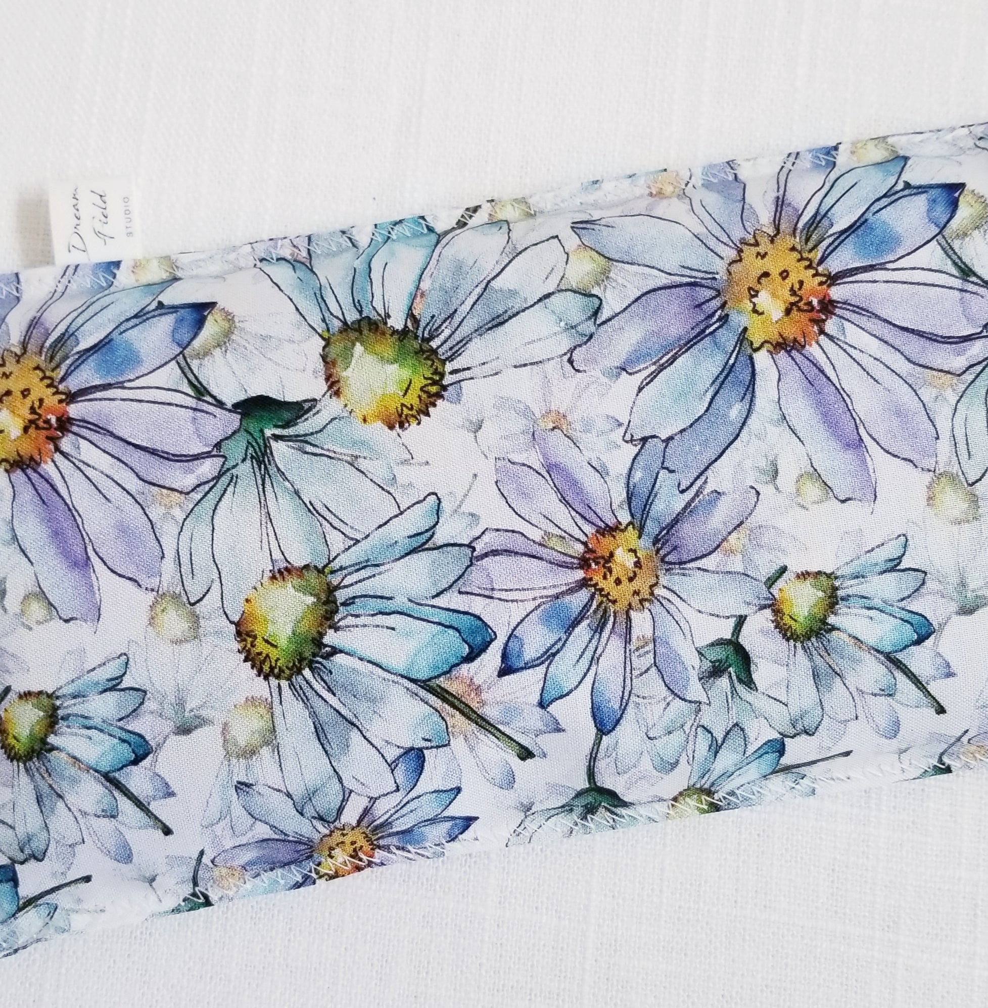 Closeup of blue watercolor daisy print eye pillow